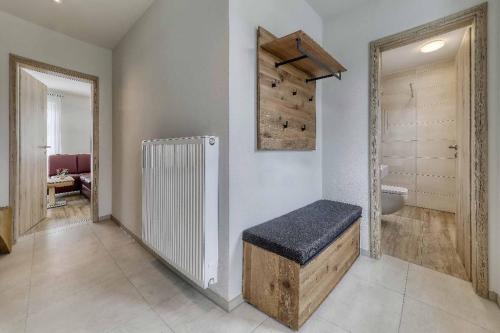 a bathroom with a bench and a sink and a mirror at Ferienchalet zum Lusen in Sankt Oswald