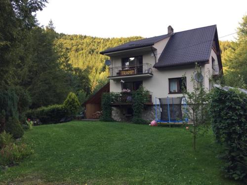 ein Haus mit einem Balkon und einem Hof in der Unterkunft Agropensjonat Tramp z góralskim spa in Żabnica