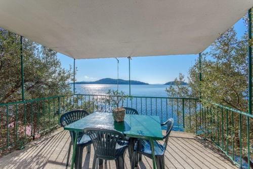 a table and chairs on a deck with a view of the water at Apartments Ivan in Prizba