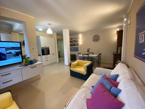a living room with a white couch and a television at ISCA BLUE BEACH Casa in Villa vicino al mare, sino a max 8 persone in Isca sullo Ionio