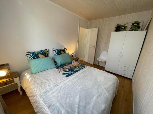 sypialnia z dużym łóżkiem z niebieskimi poduszkami w obiekcie Turgot bleu w mieście Thonon-les-Bains