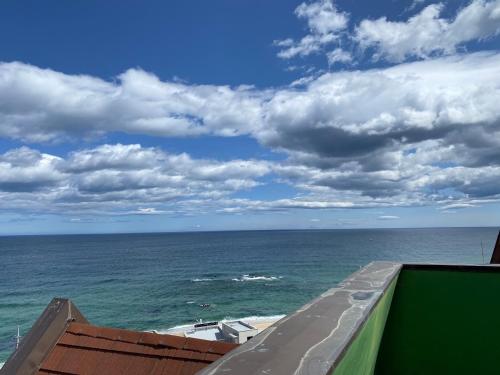 a view of the ocean from the balcony of a building at Pension Badawa in Gangneung