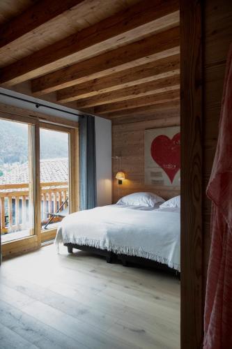 une chambre avec un lit et une grande fenêtre dans l'établissement B&B Boutique Chalet Nono, à Morzine