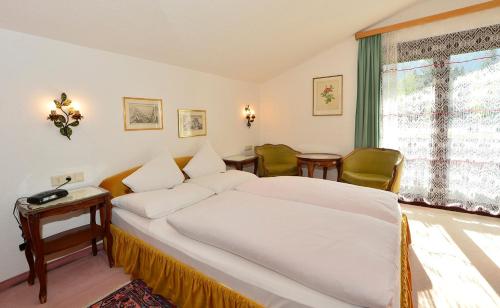 - une chambre avec un lit, une table et une fenêtre dans l'établissement Haus Orplid, à Seefeld in Tirol