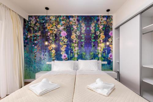a bedroom with a large bed with a floral mural on the wall at Aqua Luxury Suites by Estia in Roda