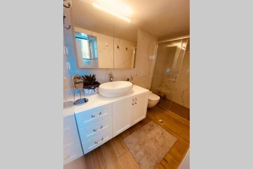 uma casa de banho com um lavatório branco e um WC. em Casa del Sud em Apolakkiá