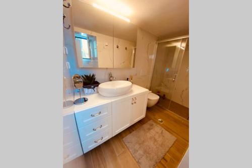 a bathroom with a white sink and a toilet at Casa del Sud in Apolakkiá