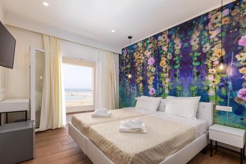 a bedroom with a bed with a painting on the wall at Aqua Luxury Suites by Estia in Roda