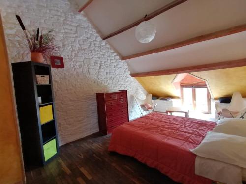 ein Schlafzimmer mit einem roten Bett und einem Fenster in der Unterkunft chambres d'hôtes proche saint Malo et mont saint Michel in La Boussac