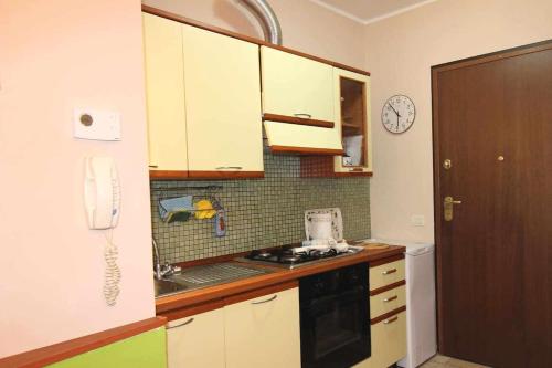 a kitchen with white cabinets and a sink and a phone at Vado al teatro monolocale in centro per 2 in Ancona