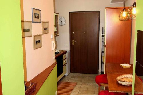 een keuken met een houten deur en een tafel en een kamer bij Vado al teatro monolocale in centro per 2 in Ancona