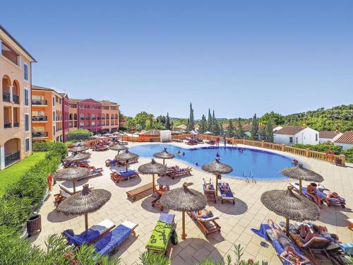 a large pool with umbrellas and people sitting in chairs at Bordoy Don Antonio in Paguera