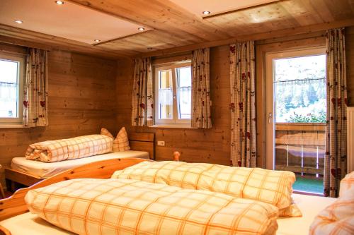 sypialnia z 2 łóżkami i oknami w pokoju w obiekcie Gostanova Appartements w mieście Gaschurn