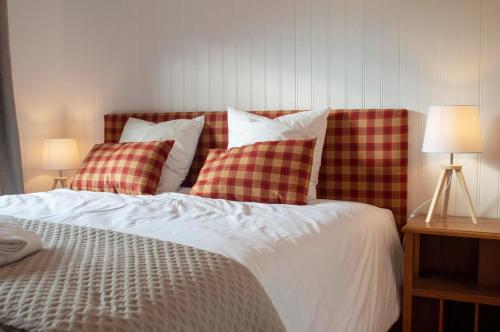 a bed with red and white pillows and two lamps at Chalet Domisiladoré - chalet haut de gamme pour 10 adultes et 2 enfants à Châtel in Châtel