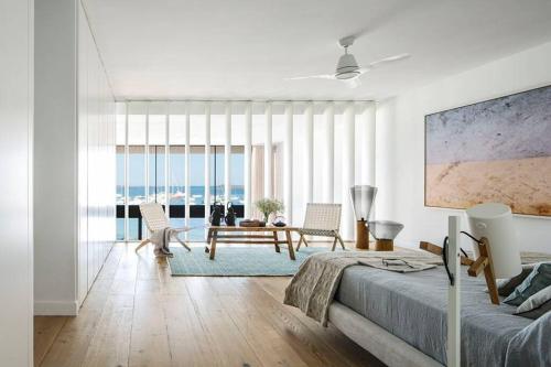 Un dormitorio blanco con una cama, una mesa y sillas. en New home on the beach, en Colonia de Sant Jordi