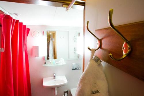 a bathroom with a sink and a towel hanging on a wall at Hotel Barken Viking in Gothenburg