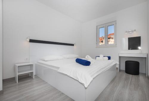 a white bedroom with a large white bed at Apartments BlueView in Postira
