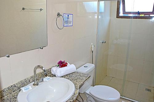 a bathroom with a toilet and a sink and a shower at Enseada dos Corais Praia Hotel in Arraial d'Ajuda