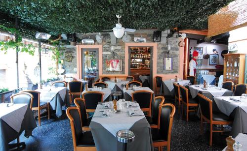 a restaurant with tables and chairs in a room at Locanda Barchetta - Room Rental in Bellagio