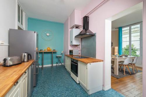 Il comprend une cuisine équipée d'un réfrigérateur et d'une table. dans l'établissement Appartement Coeur de Ville rue Saint-Laud, à Angers