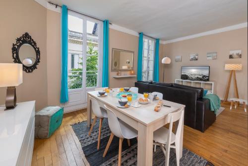 een woonkamer met een tafel en een bank bij Appartement Coeur de Ville rue Saint-Laud in Angers