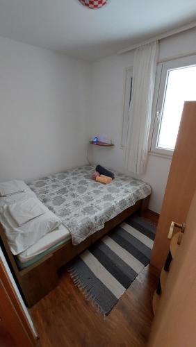 ein Bett in einem Zimmer mit einem Fenster in der Unterkunft Apartment Oaza in Rogoznica