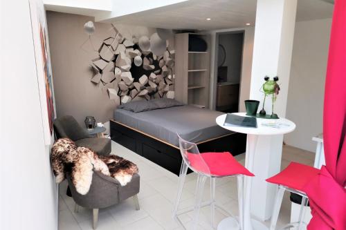 a bedroom with a bed and a table and chairs at Les Terrasses Levantines in Île du Levant