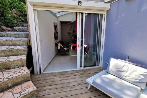 a sliding glass door to a patio with a chair at Les Terrasses Levantines in Île du Levant