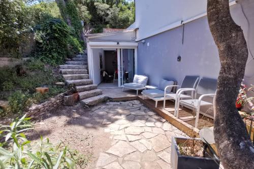 a backyard with a patio with chairs and a house at Les Terrasses Levantines in Île du Levant