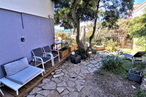 a patio with two chairs and a table at Les Terrasses Levantines in Île du Levant