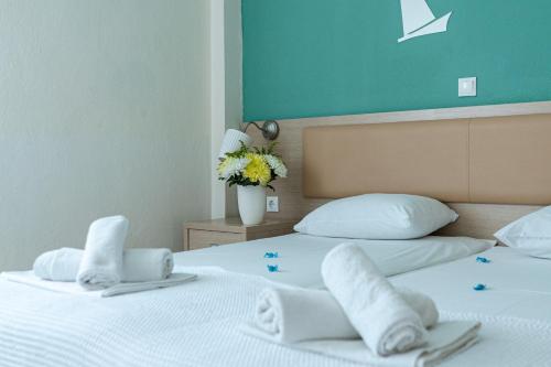 two beds in a hotel room with towels on them at Thalassenia Studios in Hanioti