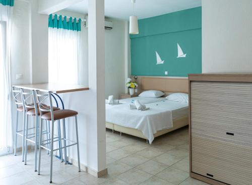 a bedroom with a bed and a table and a bar at Thalassenia Studios in Hanioti