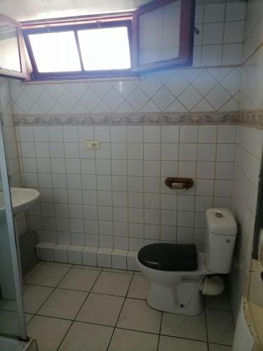 La salle de bains est pourvue de toilettes et d'un siège noir. dans l'établissement jolie appartement proche du parc des expositions, à Avignon