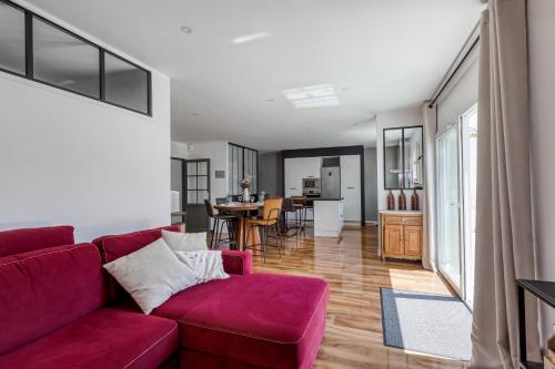 a living room with a red couch and a kitchen at Maison Dany in Salles-sur-Mer