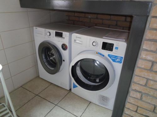 a washing machine and a washer and dryer in a room at Gîte à deux pas de l'horloge in Senzeille