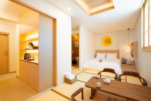 - une chambre avec un lit, une table et des chaises dans l'établissement Tomonoya Hotel & Ryokan Daecheon, à Boryeong