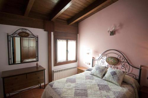1 dormitorio con cama, espejo y tocador en Apartamentos Turisticos Sanahuja, en Valbona