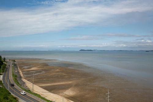 a large body of water with a road next to it at Tomonoya Hotel & Ryokan Daecheon in Boryeong