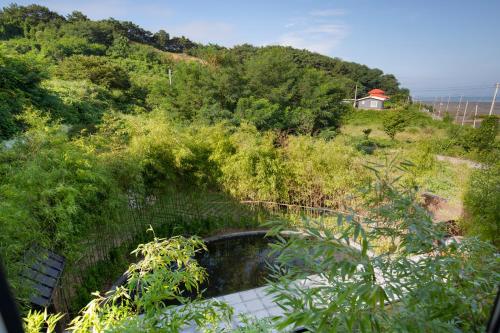 a small pond in the middle of a hill at Tomonoya Hotel & Ryokan Daecheon in Boryeong