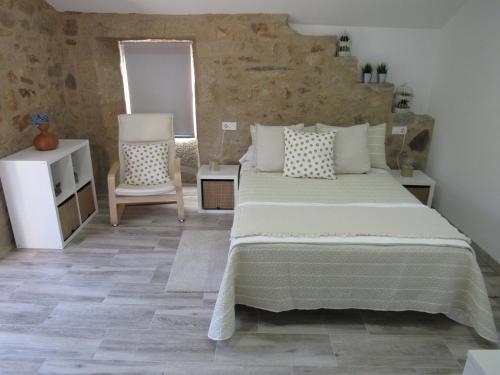 a bedroom with a large bed and a chair at Casa As Salcedas in Meis