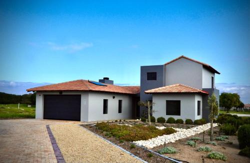 a white house with a driveway in front of it at Comfort in Langebaan in Langebaan