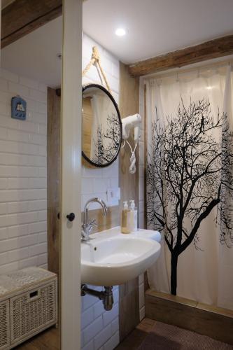 a bathroom with a sink and a tree shower curtain at Czereśniowy Dom in Jarkowice