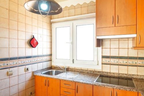拉奧利瓦的住宿－Casa Dorada，厨房设有水槽和窗户。