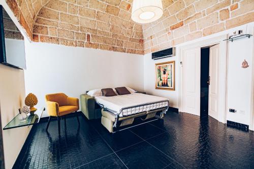ein Schlafzimmer mit einem Bett und einer Ziegelwand in der Unterkunft Dimora Giulia in Carovigno
