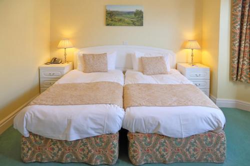 a bedroom with two beds and two night stands at Saxonville Hotel in Whitby