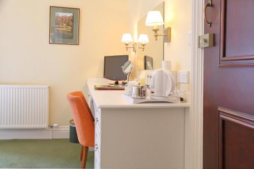a hotel room with a desk with a coffee maker on it at Saxonville Hotel in Whitby