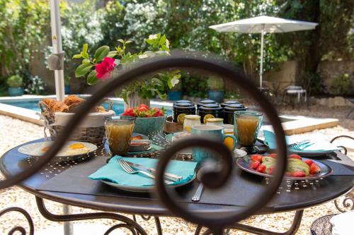 une table avec de la nourriture et des boissons dessus dans l'établissement Le Jardin de Mazan, à Mazan