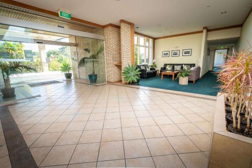 an empty lobby with plants in a building at Comfort Hotel Flames Whangarei in Whangarei