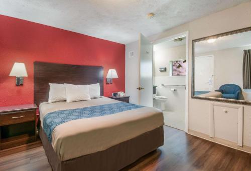 - une chambre avec un lit et un mur rouge dans l'établissement Econo Lodge, à Mechanicsburg