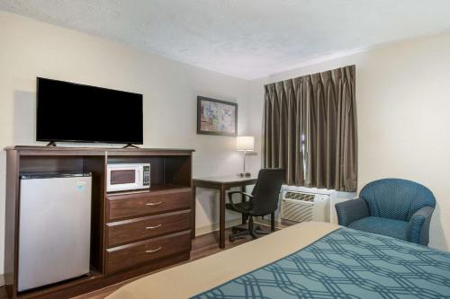 a hotel room with a bed and a flat screen tv at Econo Lodge in Mechanicsburg